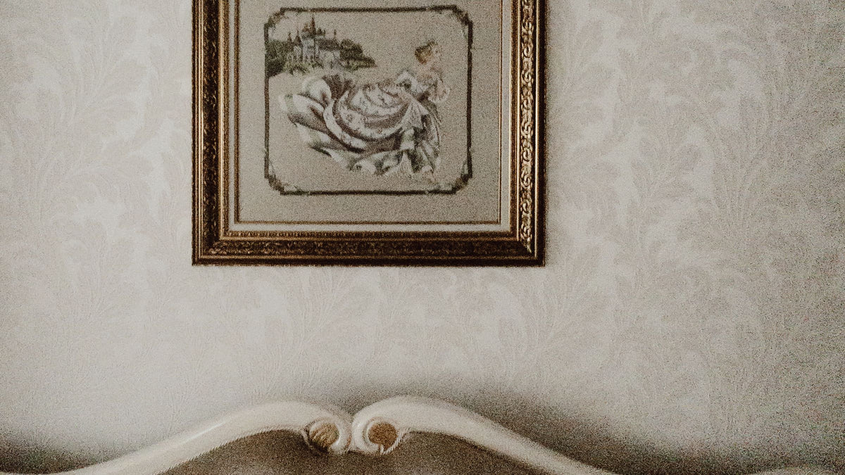 A framed portrait hanging above a living-room sofa